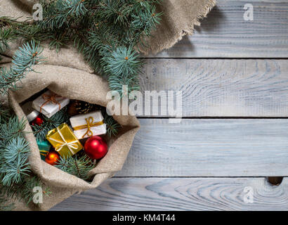 Christmas decorations in a sack on a white wooden surface Stock Photo