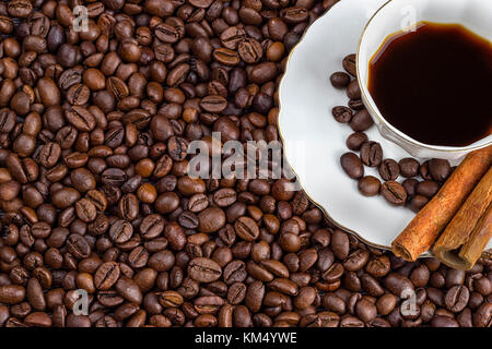 A cup of coffee with beans as background. and cinnamon Stock Photo