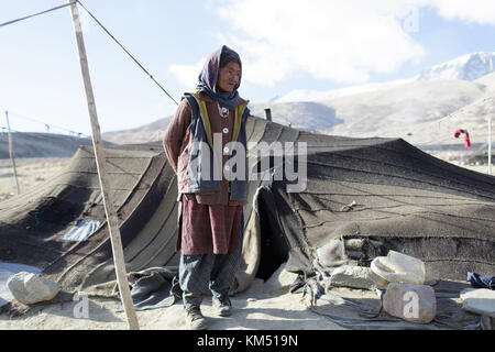 A woman from Changpa nomads standing in front of her tent from yak wool, Ladakh, Jammu and Kashmir, India. Stock Photo