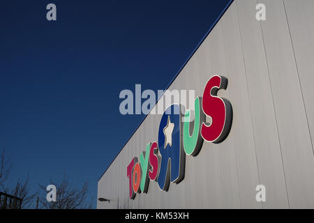 Toys R Us coloured store name logo  on a silver warehouse with blue sky in Southampton England. Stock Photo