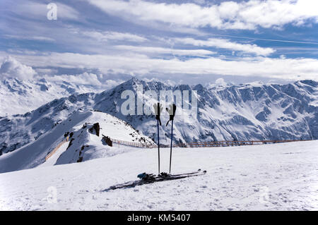 Ski, ski sticks with gloves and the piste with a safety fence at the top of Gaislachkogel near Solden in Otztal Alps in Tirol, Austria Stock Photo