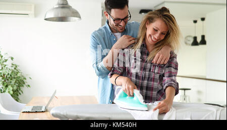 Young couple at home doing hosehold chores and ironing Stock Photo
