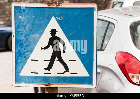 Pedestrian crossing. Old square blue and white road sign with schematic walking man in hat Stock Photo