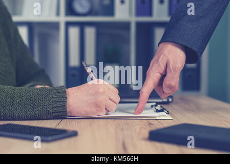 Boss giving orders and work tasks with assignment to be improved. Male hand pointing to female employee's paperwork. Stock Photo