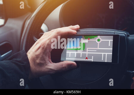 Man using GPS navigation on mobile phone in the car while driving Stock Photo