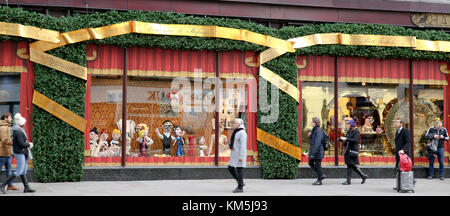 Knightsbridge. London, UK. 4th Dec, 2017. Shoppers and tourist passes by Harrods Christmas window display which is designed by Dolce & Gabbana. Its colourful display attracts thousands of visitors for the festival season. Credit: Dinendra Haria/Alamy Live News Stock Photo