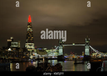 London, UK. 4th Dec, 2017. The Shard Christmas Lights. The top of The Shard skyscraper building glows red as part of the annual lighting installation. Seen next to Tower Bridge the show started at 7:20 Monday night. Credit: Guy Corbishley/Alamy Live News Stock Photo