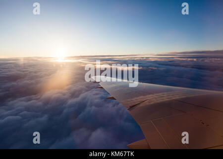 Watching the sunrise from an airplane Stock Photo