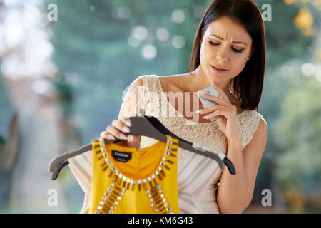 Girl looking doubtful purchasing clothes Stock Photo