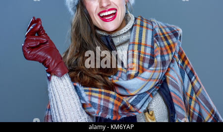 Winter things. Closeup on smiling trendy woman in fur hat isolated on cold blue snapping fingers Stock Photo