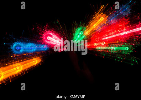 Trails of multicolored radial lights blurred on black, can use background Stock Photo