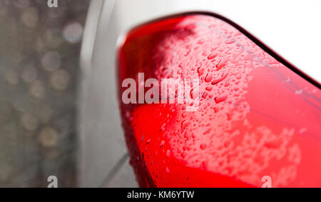 Raindrops on a red car headlight Stock Photo