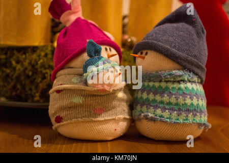 Christmas decoration: Handmade sock snowman family with cute baby in front of advent wreath. Stock Photo