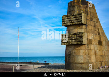 Les Braves Memorial honoring fallen US solders on the Normandy Coast at Omaha Beach with an American flag and the English Channel in the background Stock Photo