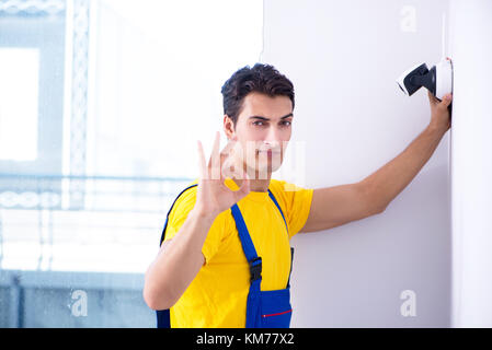 Contractor installing surveillance CCTV cameras in office Stock Photo