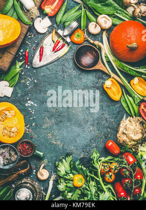 Pumpkin and Others organic harvest vegetables and ingredients with cooking spoon on rustic background, top view, frame, vertical Stock Photo