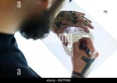 London, UK, Tattoo artist at work in his local business studio, tattooist Stock Photo