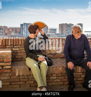 Older Spanish couple, woman using fan for sunshade Stock Photo