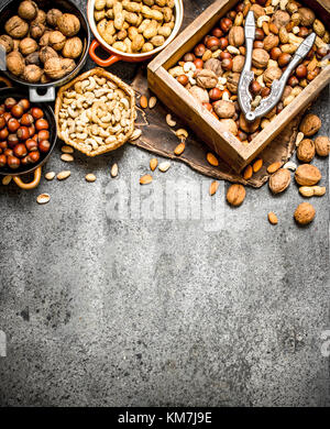 Many different nuts in the box and bowls. On rustic background. Stock Photo