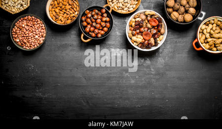 Various nuts in bowls. On a black chalkboard. Stock Photo