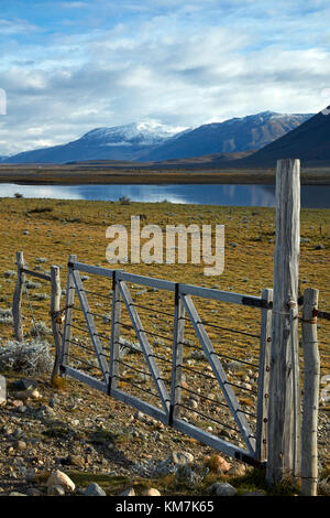 Gate, farmland and lake near EL Chalten, Patagonia, Argentina, South America Stock Photo