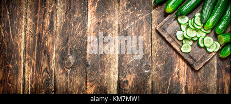 Sliced cucumbers in a bowl. On wooden background. Stock Photo
