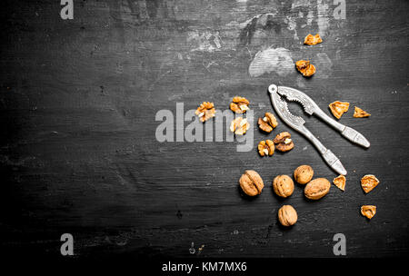 Walnuts with Nutcracker. On a black chalkboard Stock Photo