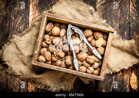 Walnuts in the box with the Nutcracker. On wooden background. Stock Photo
