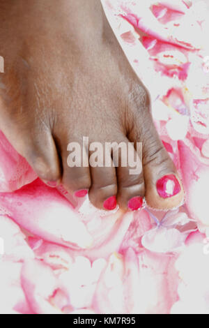 African woman soaking her feet in bowl of water and flower pedals Stock ...