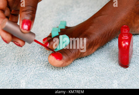 African woman painting her toenails Stock Photo