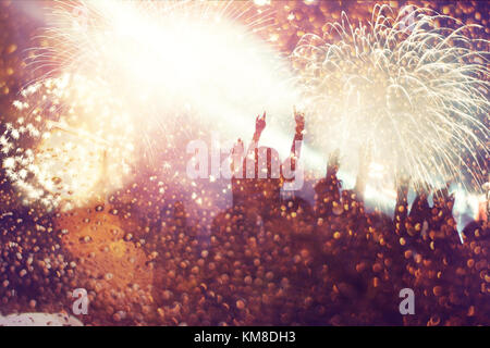 cheering crowd watching fireworks at New Year - holiday celebration background Stock Photo