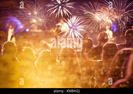 cheering crowd watching fireworks at New Year - holiday celebration background Stock Photo