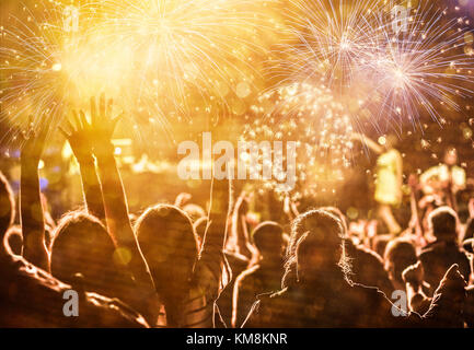 Cheering crowd watching fireworks at New Year Stock Photo