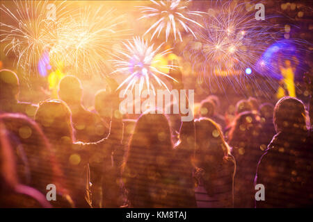 Cheering crowd watching fireworks at New Year Stock Photo