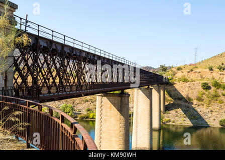 Abandoned truss road-rail bridge with the rail track above the roadway crossing the Douro River in Pocinho, Douro region, Portugal Stock Photo