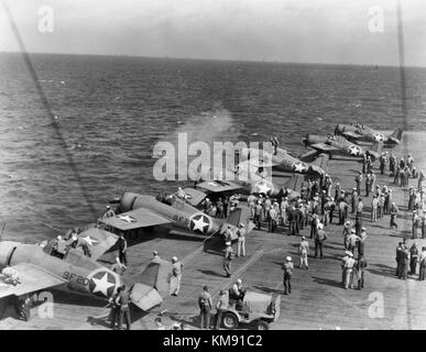 Testing machine guns of Grumman F4F-4 Wildcat fighters aboard USS Ranger (CV-4), while en route from the U.S. to North African waters, circa early November 1942. Note the special markings used during this operation, with a yellow ring painted around the national insignia on aircraft fuselages. Operation Torch Stock Photo