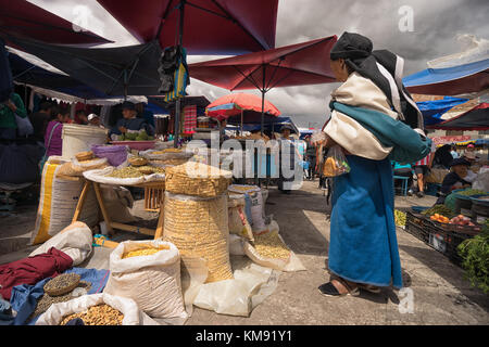 Otavalo, Ecuador - December 2, 2017: closeup of an indigenous woman wearing traditional dress standing in the Saturday outdoor artisan and farmer's ma Stock Photo
