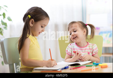 Kids drawing in kindergaten. Children painting in nursery. Preschooler with pen at home. Creative toddlers. Stock Photo