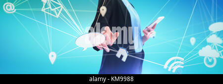 Mid section of businesswoman using mobile phone while using imaginary interface against abstract blue background Stock Photo