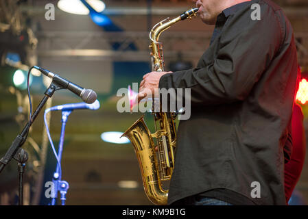 Musicial music live band performing on a stage with different lights. Saxophonist plays. Stock Photo
