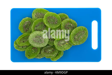 Top view of several slices of glazed kiwi fruit on a blue plastic cutting board isolated on a white background. Stock Photo