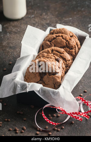 freshly baked chocolate chip cookies with milk on rustic background Stock Photo