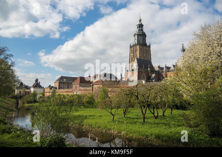Walburgiskerk and city walls in Zupthen, Holland. In the foreground an orchard full of blooming fruit trees. Stock Photo