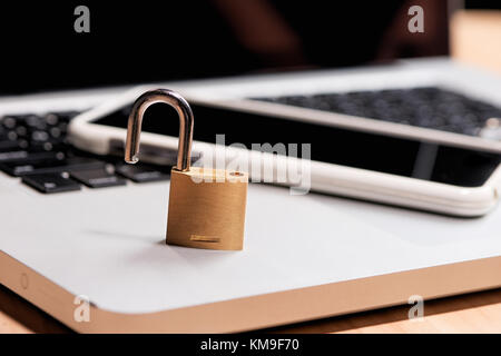 Smartphone and padlock is lying on a laptop keyboard Stock Photo