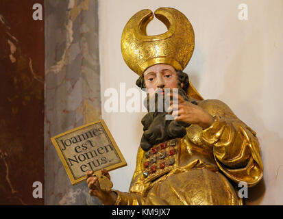 Statue of a Saint holding a sign with the Latin text Joannes est Nomen ...