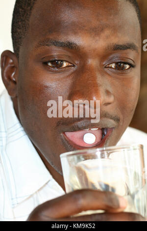 African man taking pill Stock Photo
