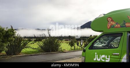 A long white cloud slides over the pasture surface of a sheep herd near Te Anau in southern New Zealand. Land of the long white cloud - so also called the Maori their home. (28 January 2016) | usage worldwide Stock Photo