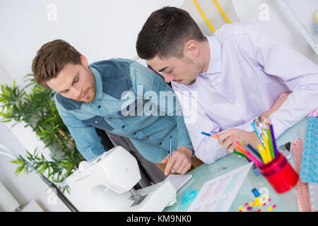two fashion designers using sewing machine in a studio Stock Photo