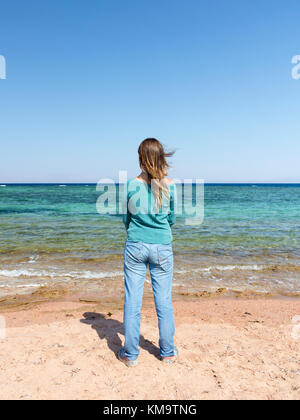 Rear view of teenage girl standing in front of sea, Dahab, Egypt Stock Photo