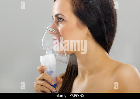 inhalation young woman keeping inhale mask Stock Photo